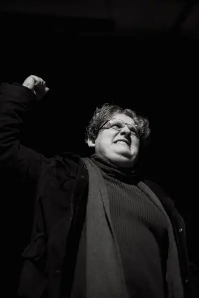 An actor in black and white punching the air